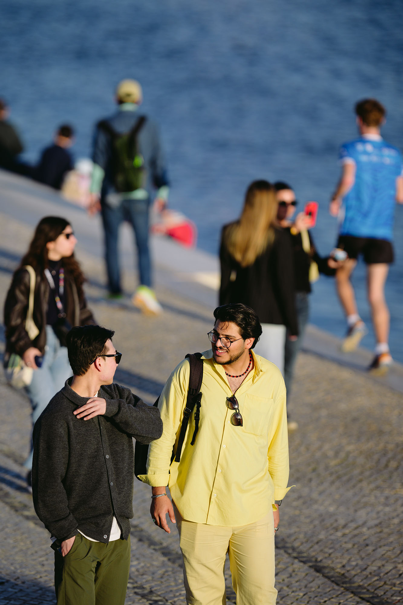 Two men chatting during sunset in Belem area of Lisbon, Portugal