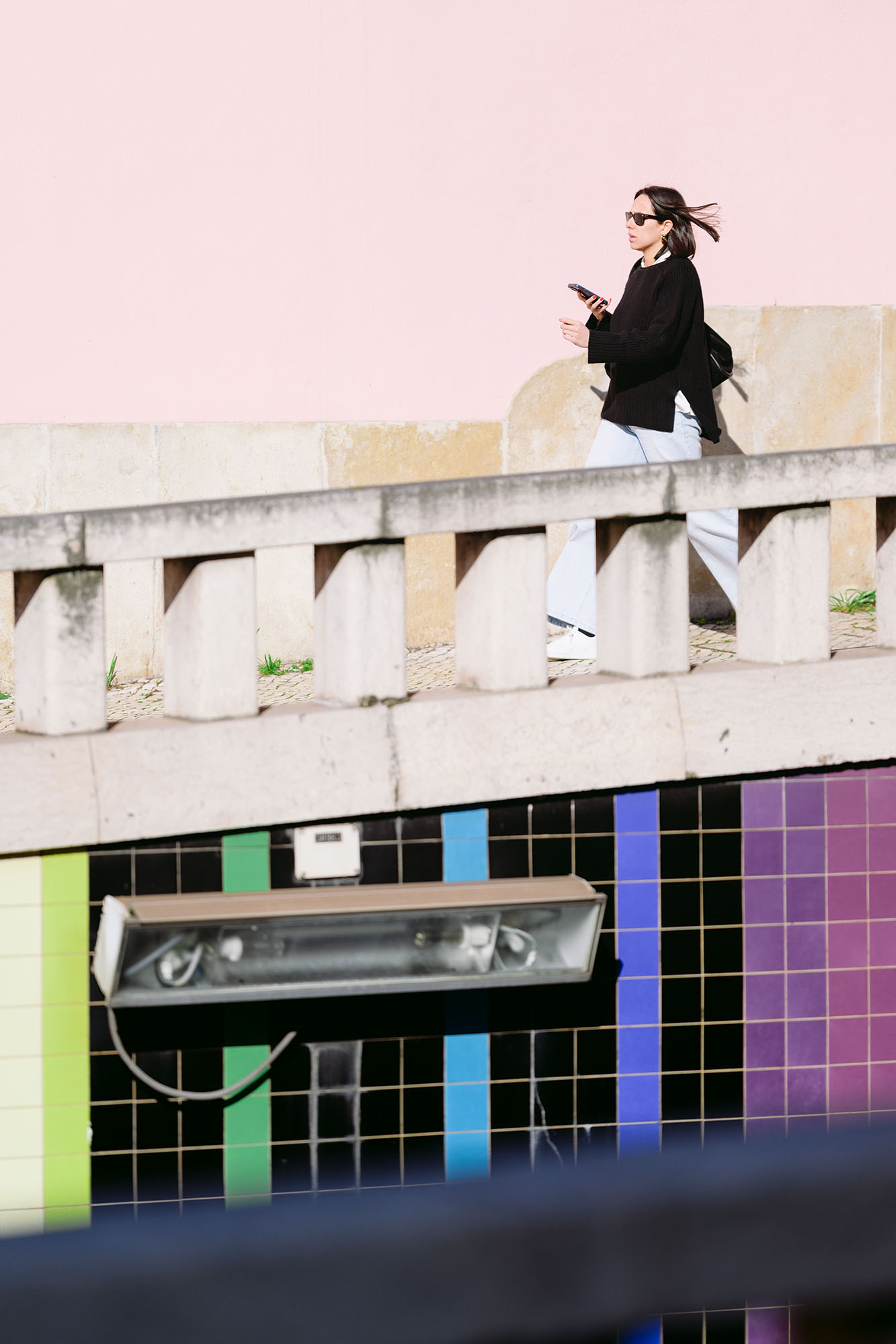 Woman walking down Avenida Infante Santo in Alcantara area of Lisbon, Portugal